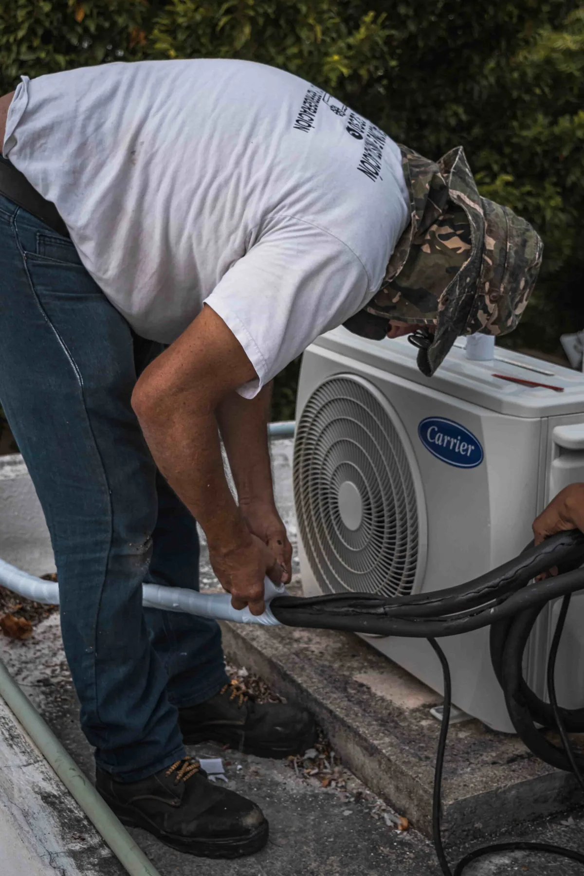 Technician connecting a Carrier outdoor cooling unit
